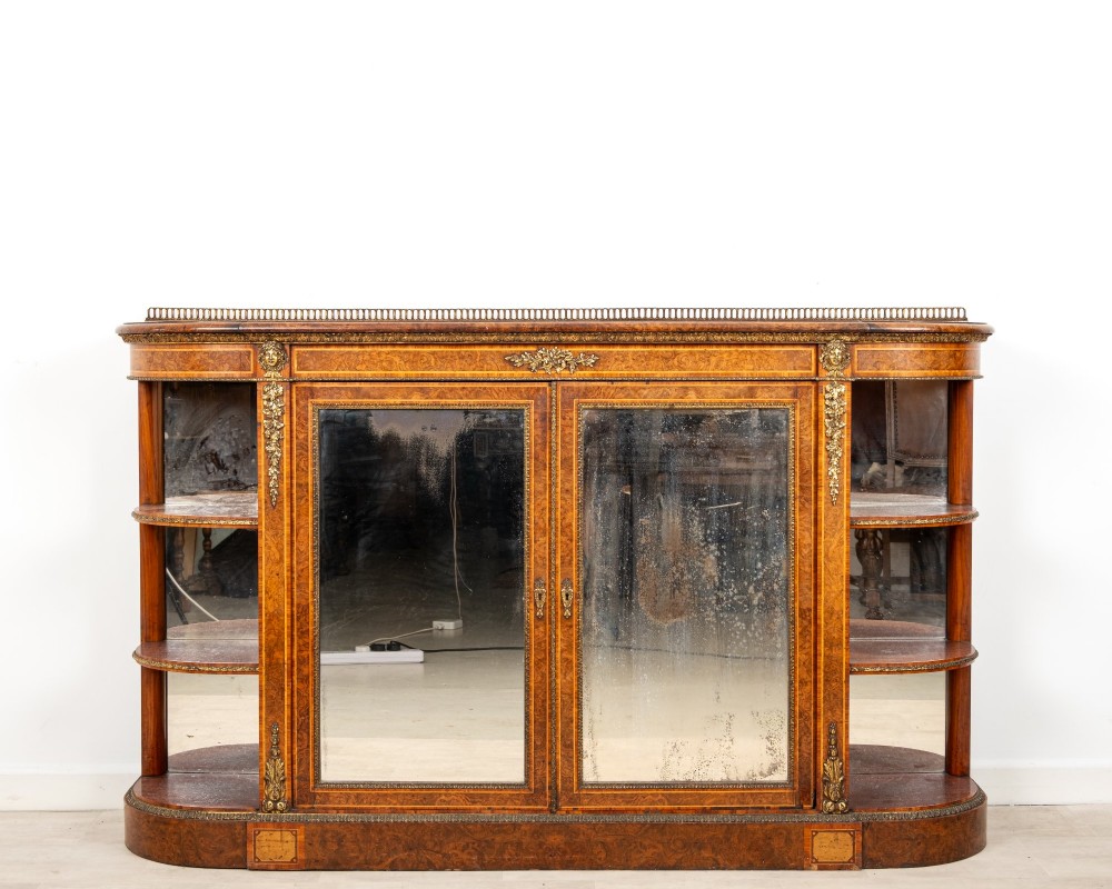 A Victorian burr walnut credenza featuring central mirrored doors, open curved side shelves, and detailed gilt ormolu mounts.
