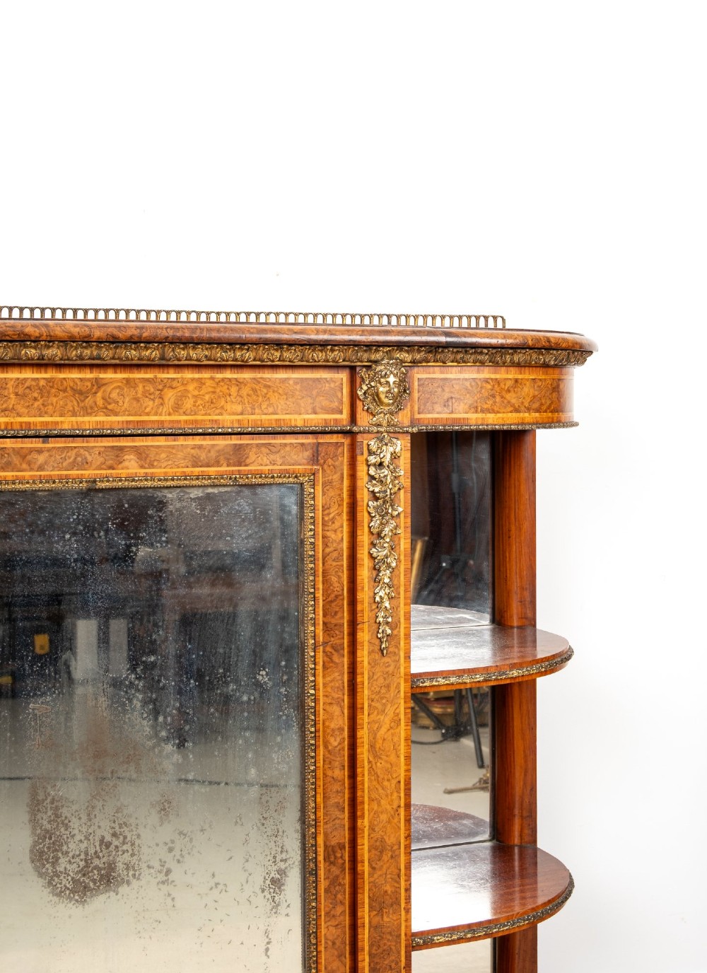 A Victorian burr walnut credenza featuring central mirrored doors, open curved side shelves, and detailed gilt ormolu mounts. View III