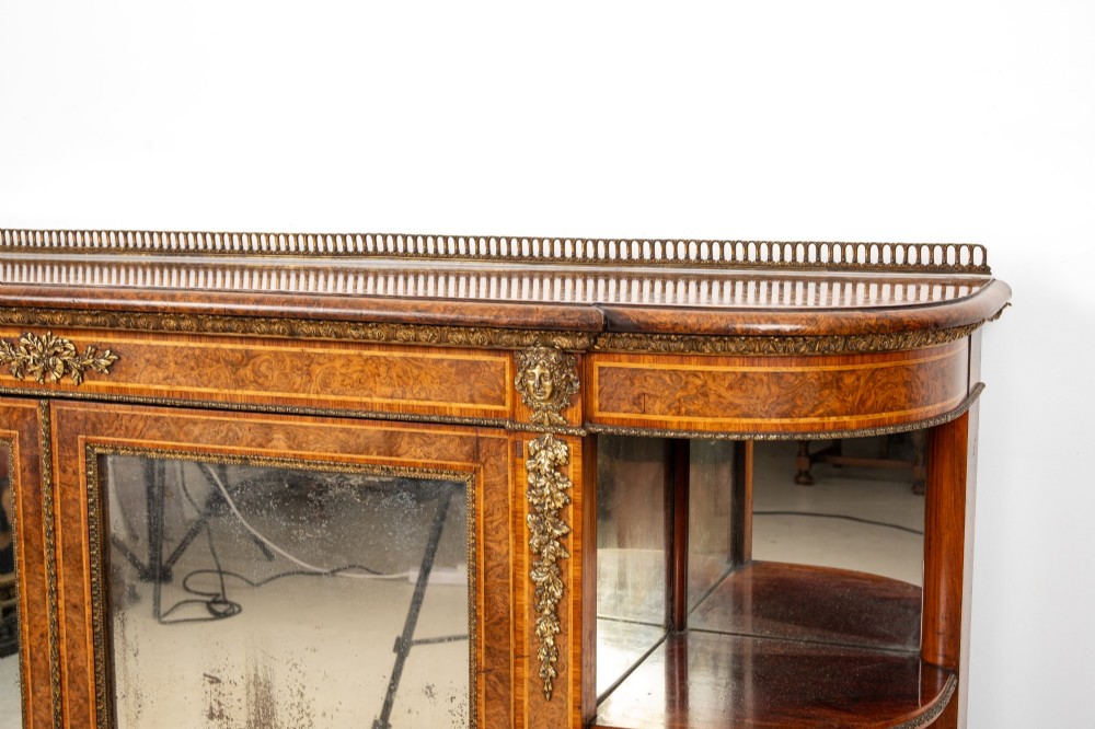 A Victorian burr walnut credenza featuring central mirrored doors, open curved side shelves, and detailed gilt ormolu mounts. View IV