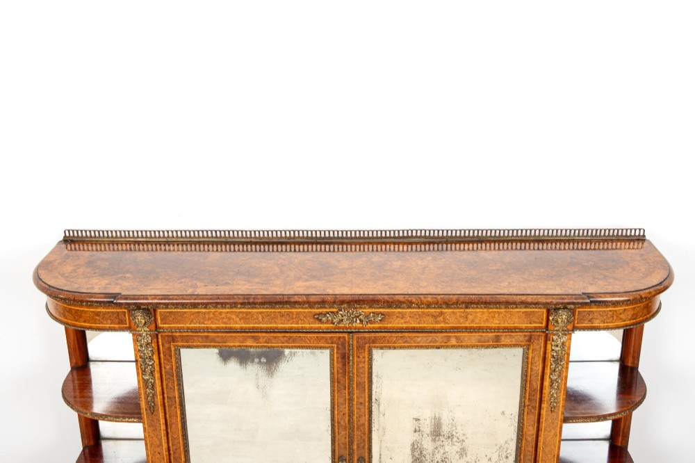 A Victorian burr walnut credenza featuring central mirrored doors, open curved side shelves, and detailed gilt ormolu mounts. View VIII