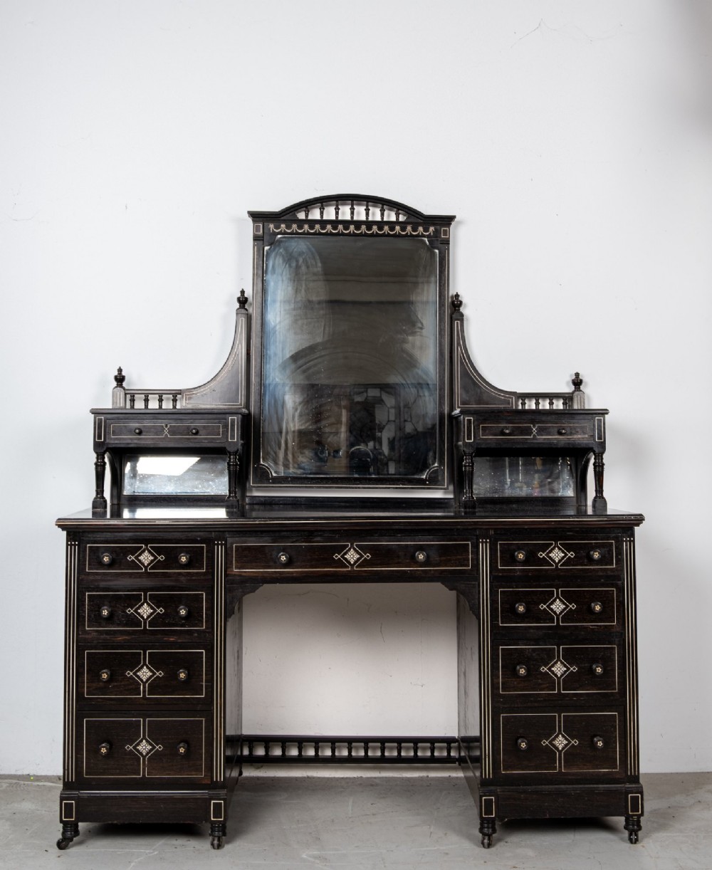 A six-piece late Victorian ebonised bedroom suite featuring bone inlay, comprising a half-tester bed, mirror wardrobe, dressing table, marble-top washstand, nightstand, and towel rail. View II