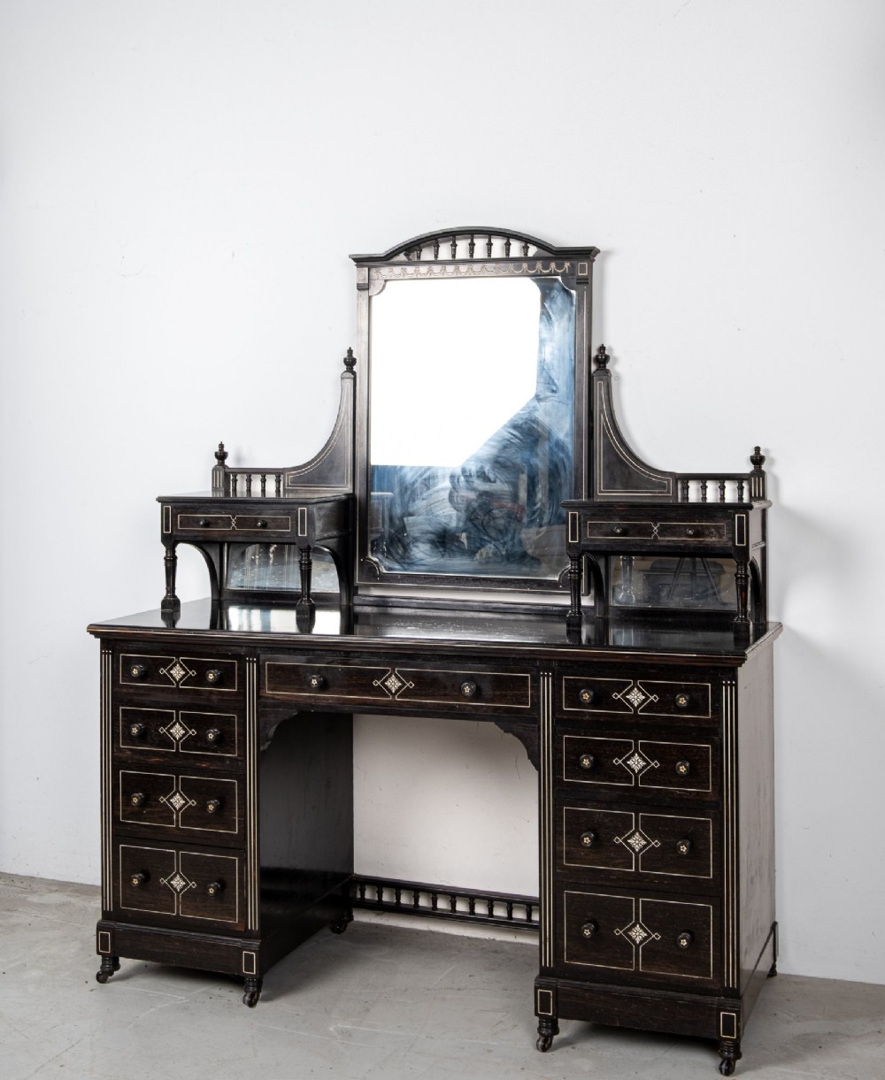 A six-piece late Victorian ebonised bedroom suite featuring bone inlay, comprising a half-tester bed, mirror wardrobe, dressing table, marble-top washstand, nightstand, and towel rail. View III