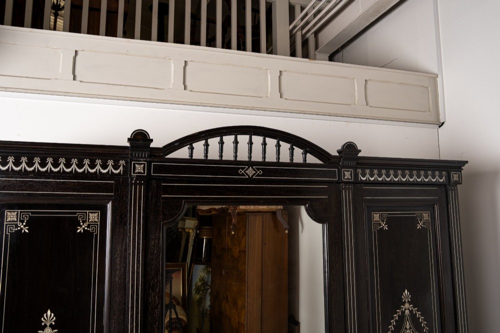 A six-piece late Victorian ebonised bedroom suite featuring bone inlay, comprising a half-tester bed, mirror wardrobe, dressing table, marble-top washstand, nightstand, and towel rail. View X