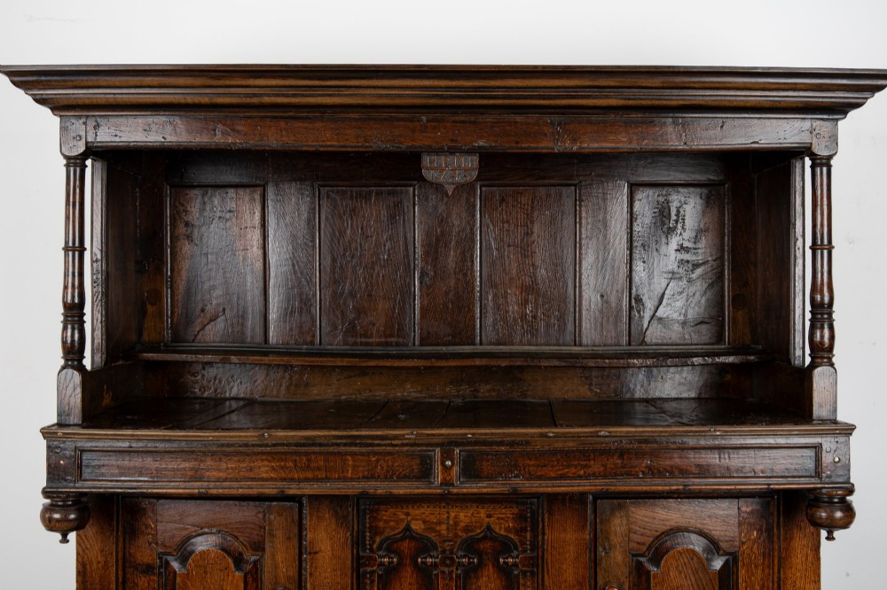An 18th-century dark Welsh oak cwpwrdd tridarn three-tier press cupboard featuring fielded panels and turned canopy posts. View V