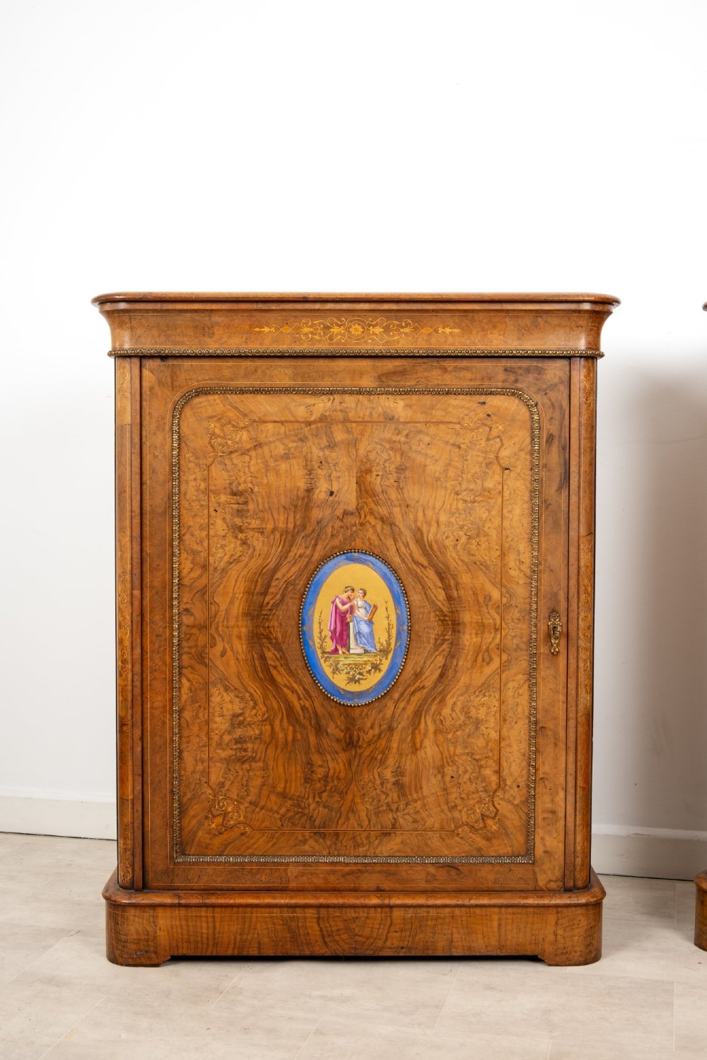 A pair of Victorian burr walnut side cabinets featuring inlaid boxwood detailing, gilt metal trim, and central oval blue porcelain plaques painted with classical figures. View III