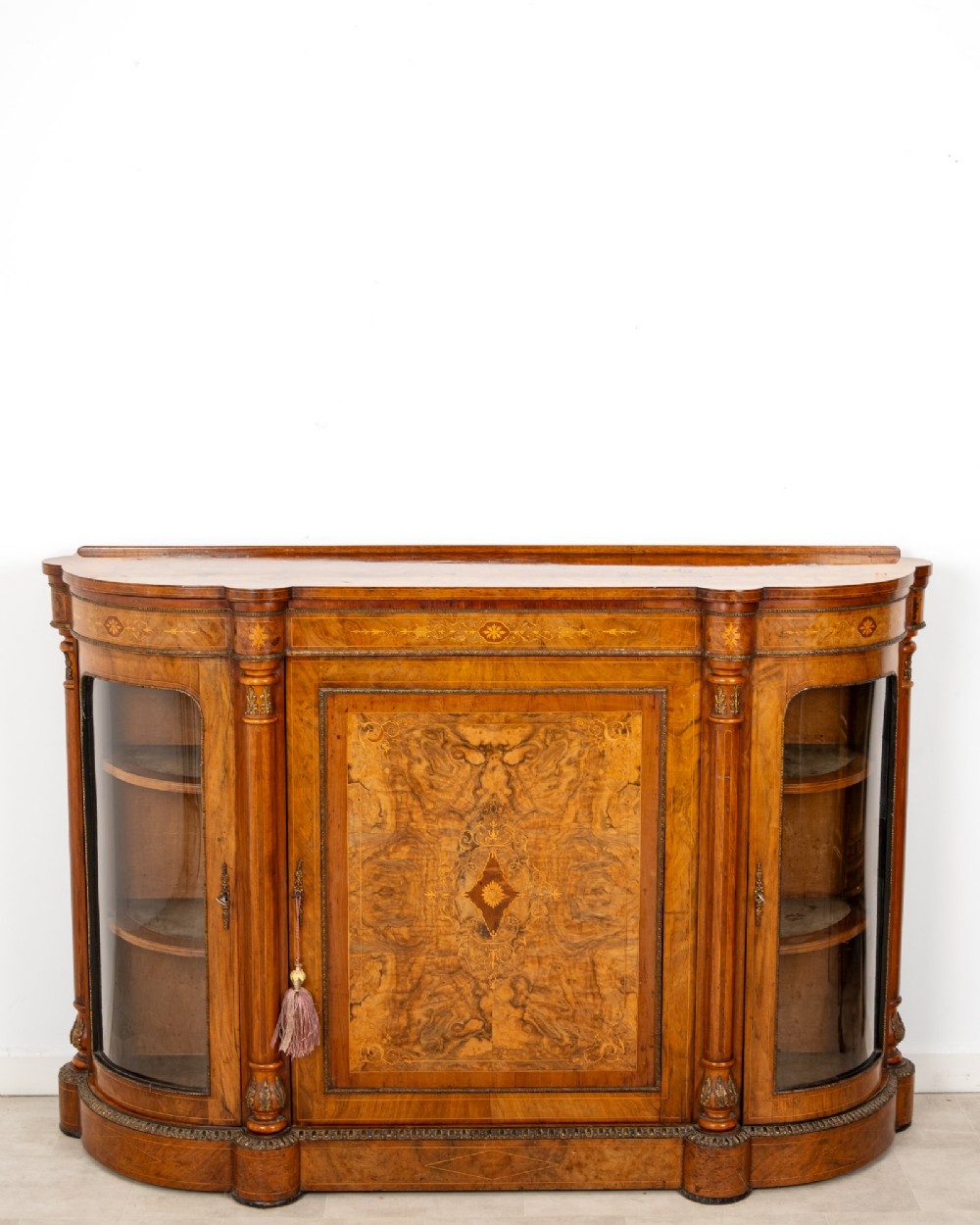An antique Victorian burr walnut credenza featuring a central inlaid marquetry door flanked by two curved glazed display cabinets and gilt mounts. View III