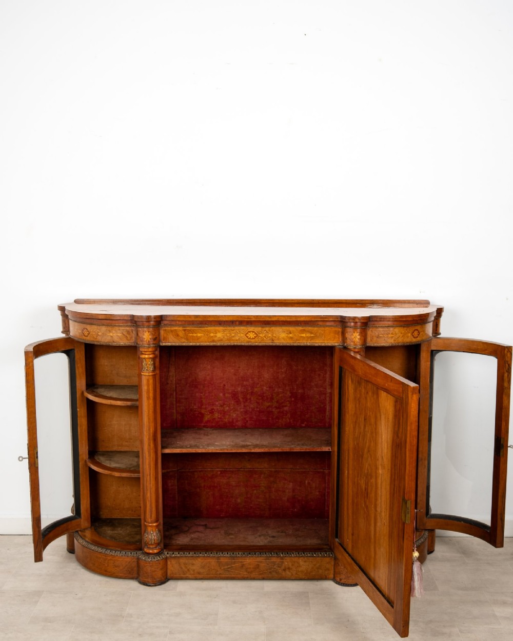 An antique Victorian burr walnut credenza featuring a central inlaid marquetry door flanked by two curved glazed display cabinets and gilt mounts. View VIII