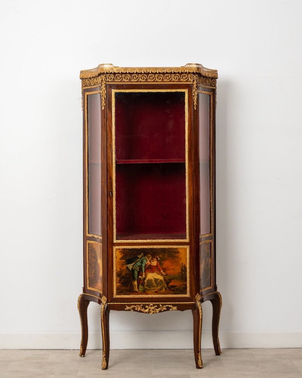 An antique French mahogany vitrine display cabinet featuring hand-painted Vernis Martin panels, gilt bronze mounts, cabriole legs, and a red velvet interior.