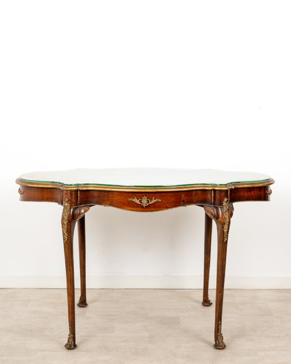 A French Louis XV style centre table featuring a serpentine glass-covered top with a painted figurative scene, cabriole legs, and ornate gilt bronze mounts. View III