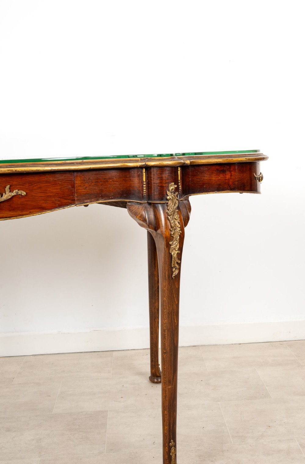 A French Louis XV style centre table featuring a serpentine glass-covered top with a painted figurative scene, cabriole legs, and ornate gilt bronze mounts. View IV