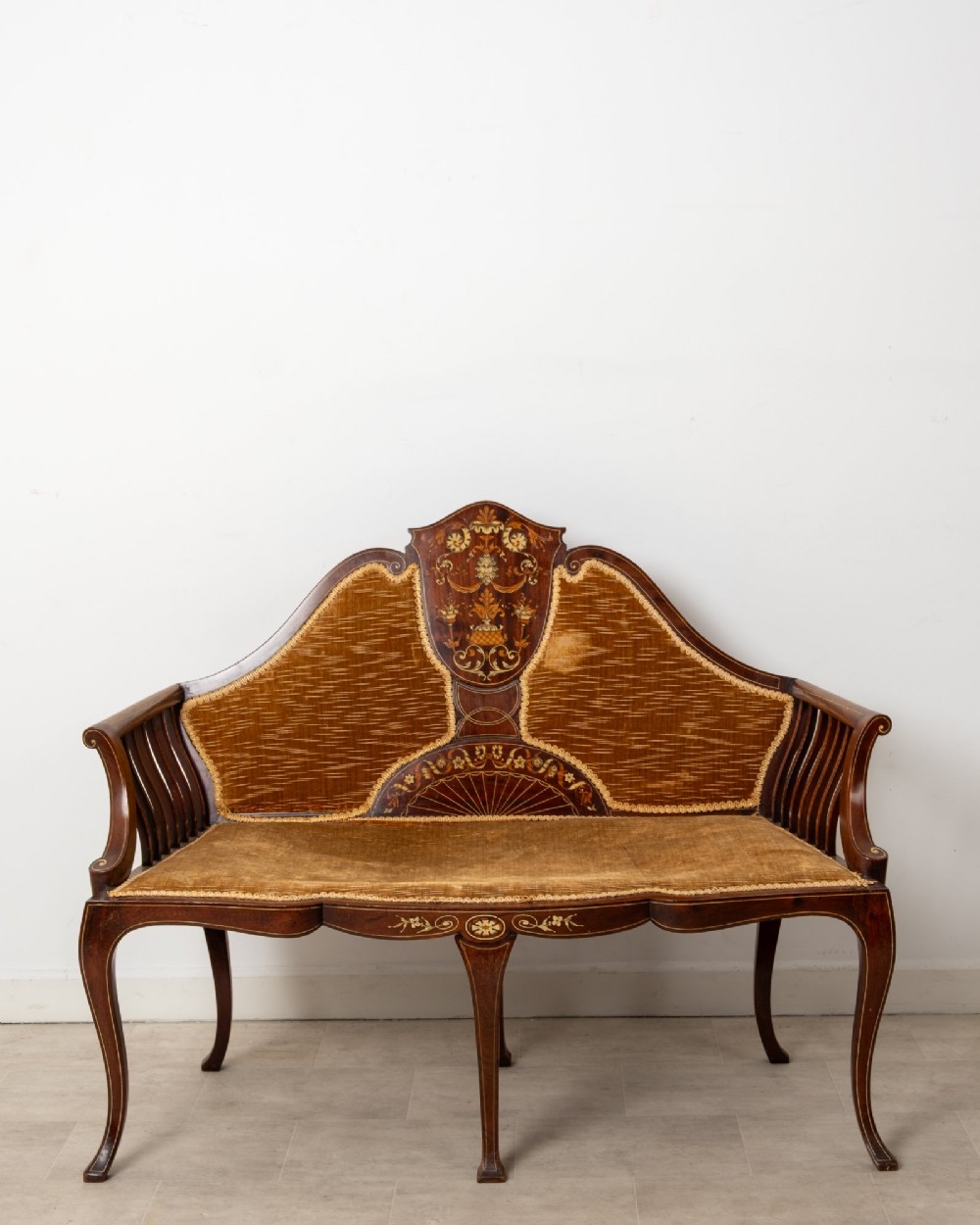 An Edwardian mahogany settee featuring floral marquetry inlay on a central back panel, slatted arms, cabriole legs, and gold-brown velvet upholstery. View II