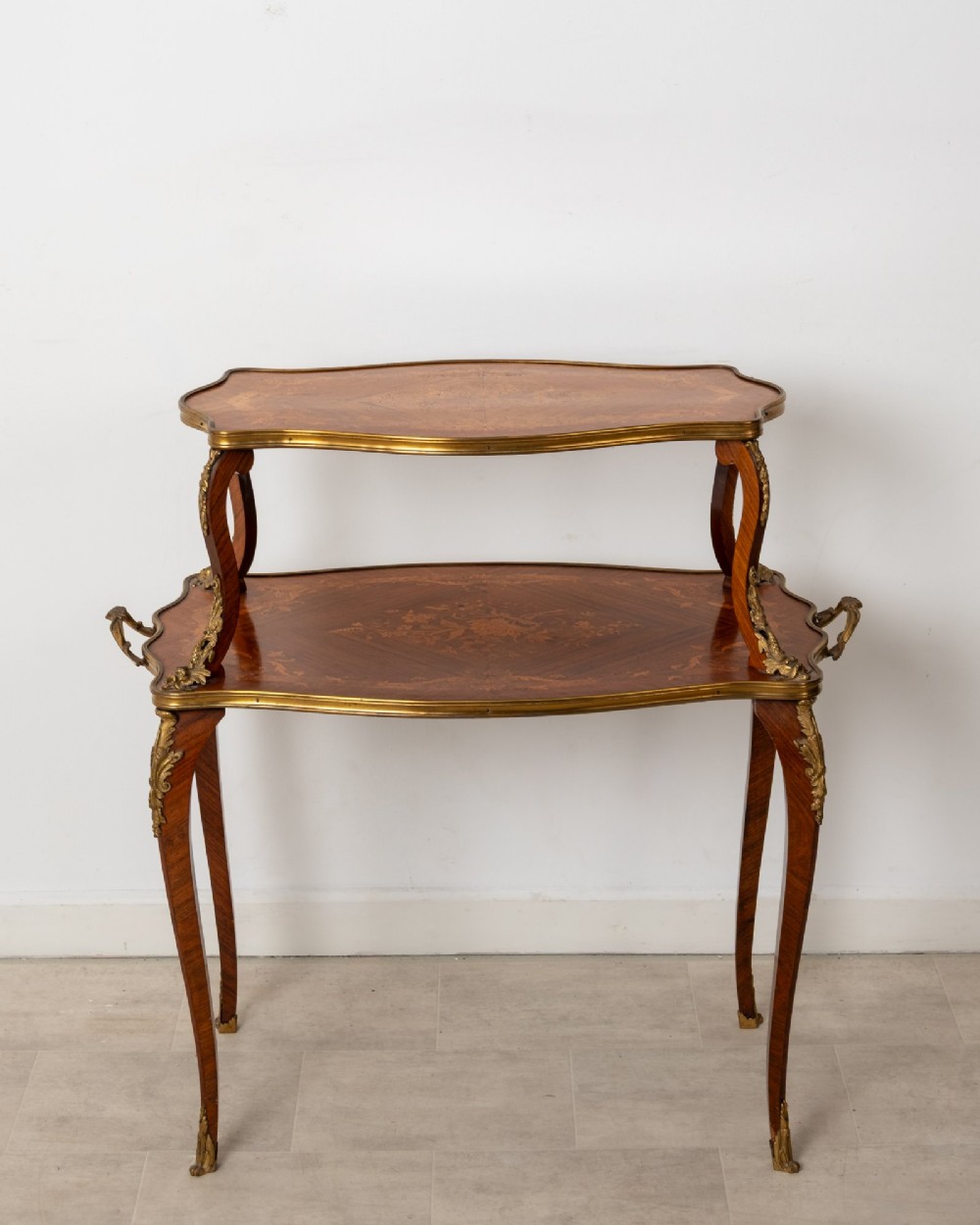 An antique Louis XV style two-tier kingwood side table featuring floral marquetry inlay, serpentine edges, and gilt-bronze mounts on cabriole legs. View II