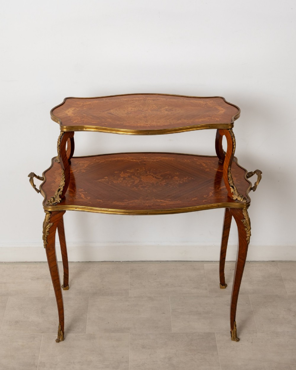An antique Louis XV style two-tier kingwood side table featuring floral marquetry inlay, serpentine edges, and gilt-bronze mounts on cabriole legs. View IV