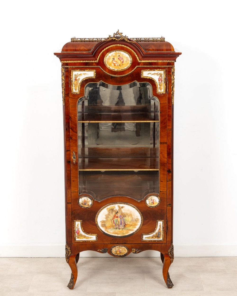An antique French walnut vitrine featuring a single glass door, hand-painted porcelain plaques, gilt-bronze ormolu mounts, and cabriole legs. View II