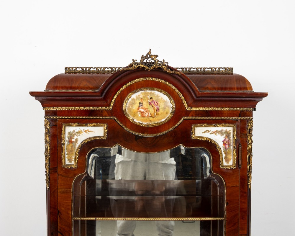 An antique French walnut vitrine featuring a single glass door, hand-painted porcelain plaques, gilt-bronze ormolu mounts, and cabriole legs. View V