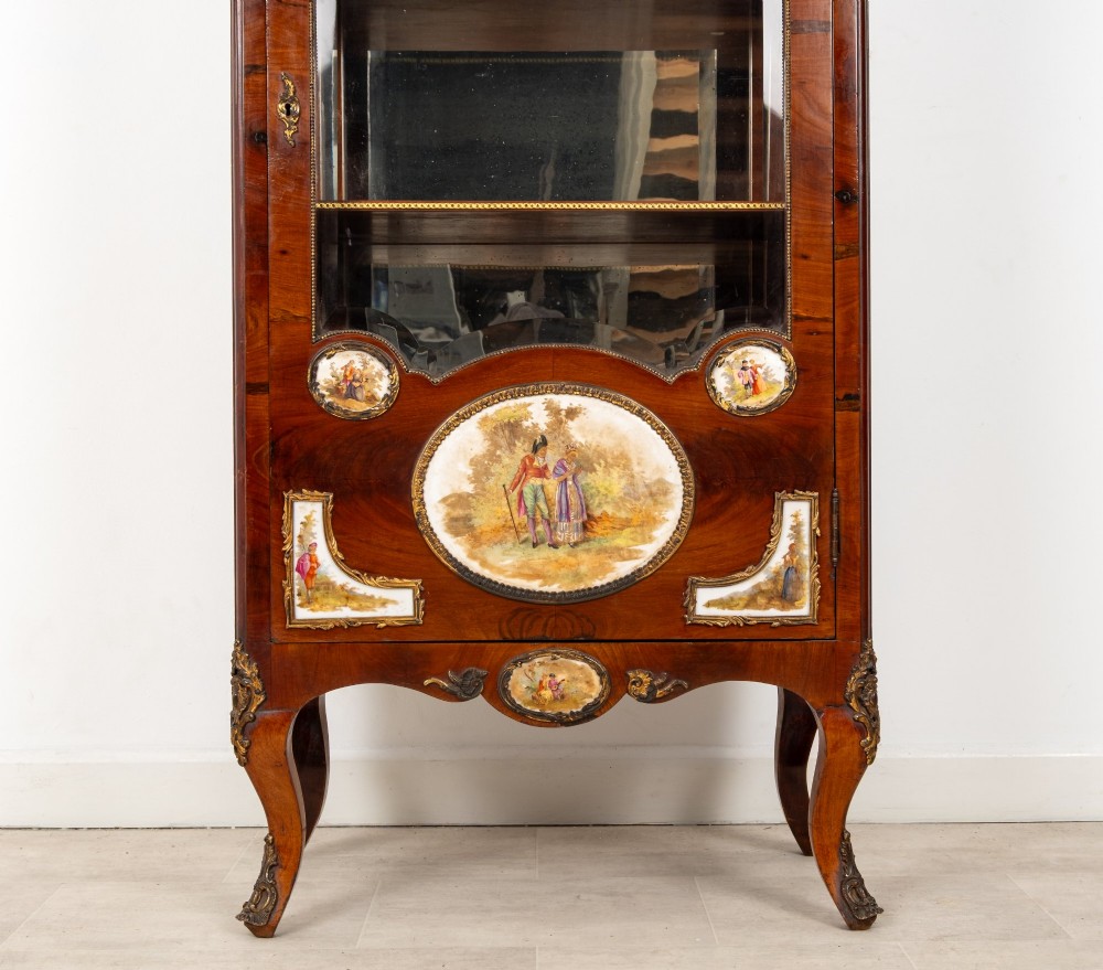 An antique French walnut vitrine featuring a single glass door, hand-painted porcelain plaques, gilt-bronze ormolu mounts, and cabriole legs. View VI