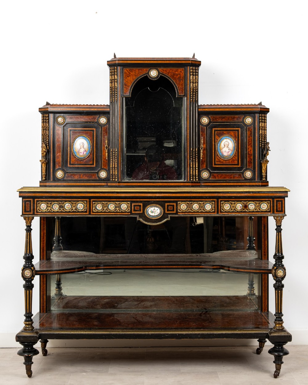 A nineteenth-century French ebonised and amboyna bonheur du jour desk featuring porcelain plaques, mirrored panels, turned legs, and brass mounts. View II