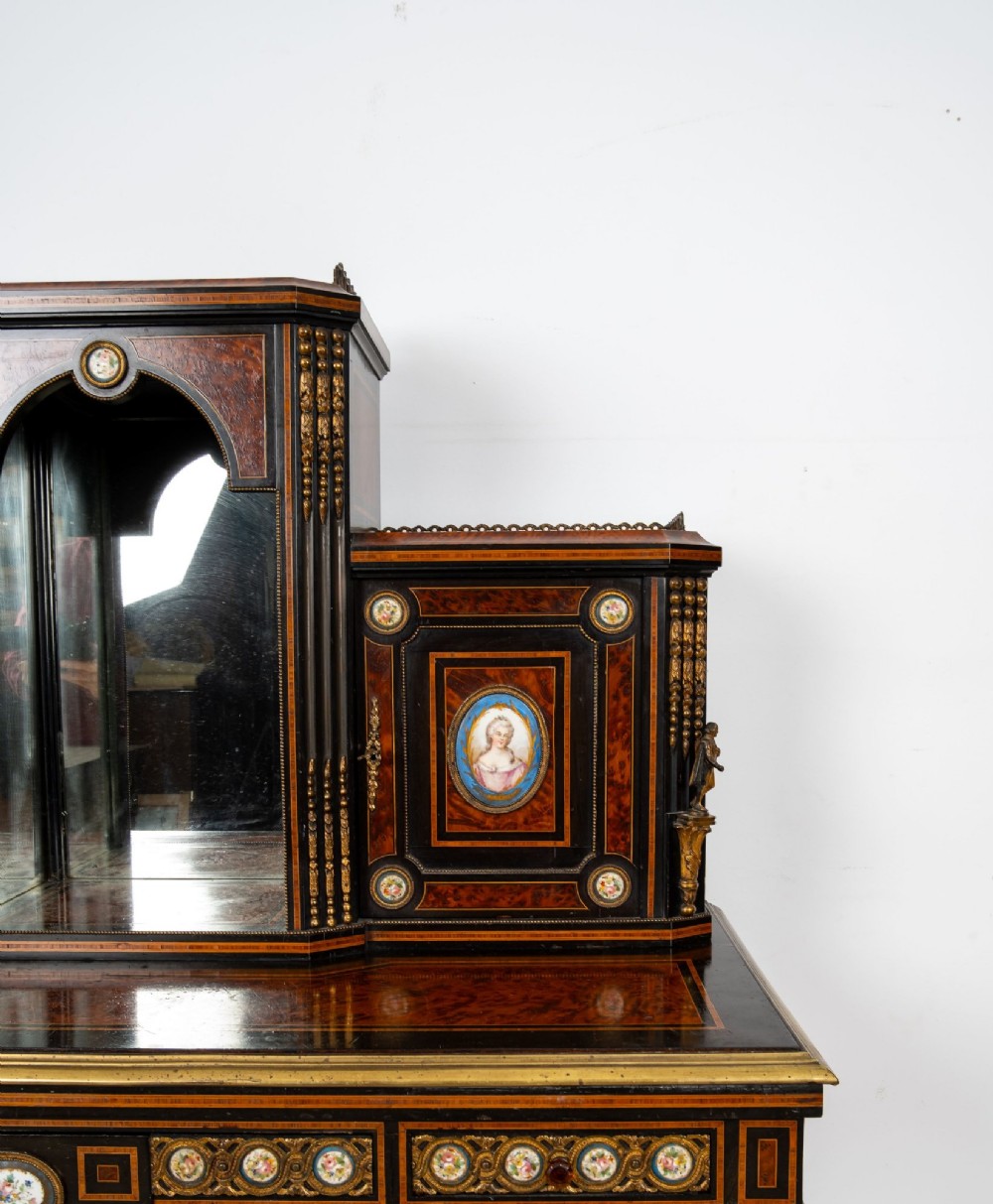 A nineteenth-century French ebonised and amboyna bonheur du jour desk featuring porcelain plaques, mirrored panels, turned legs, and brass mounts. View VII