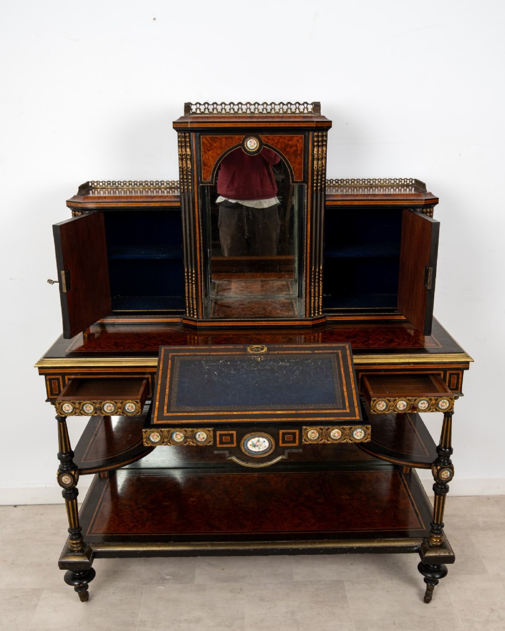 A nineteenth-century French ebonised and amboyna bonheur du jour desk featuring porcelain plaques, mirrored panels, turned legs, and brass mounts. View VIII