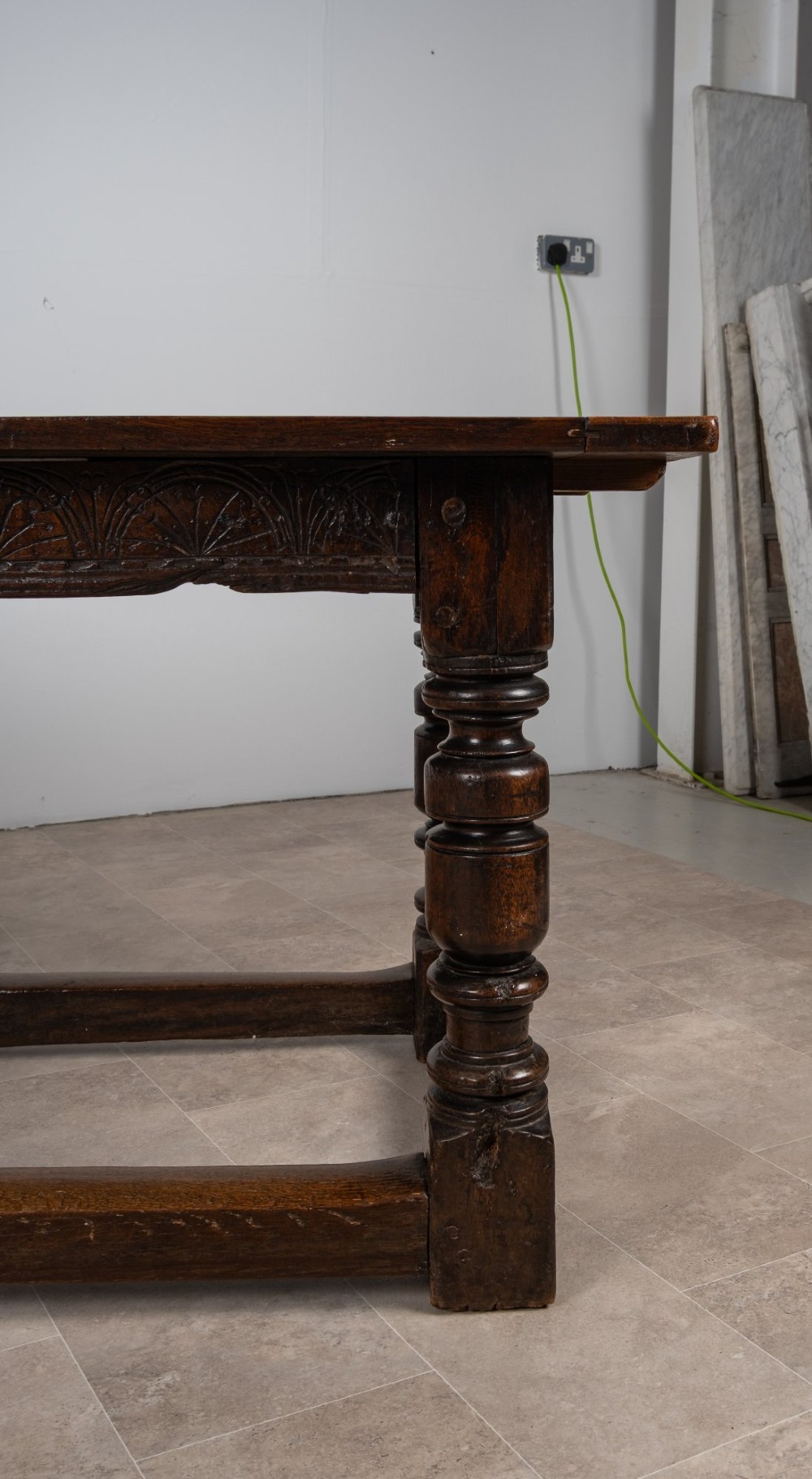 A long 18th-century oak refectory dining table featuring a carved lunette frieze, turned baluster legs, and sturdy box stretchers. View VI