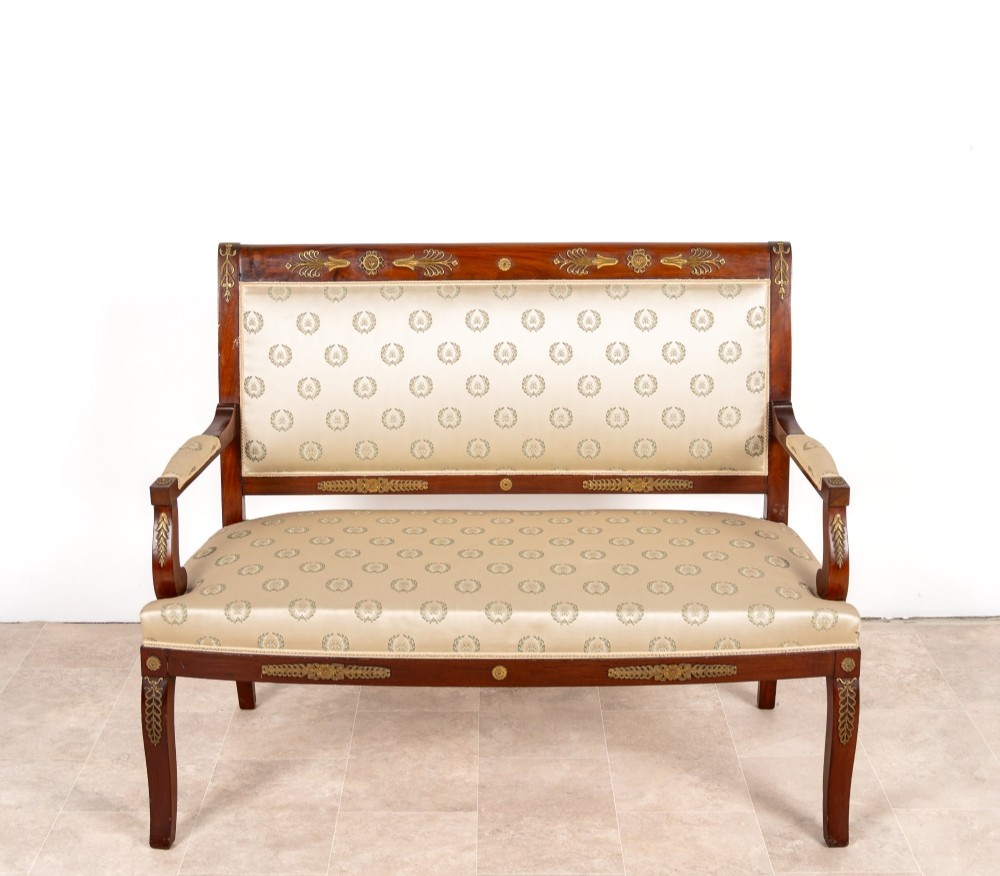 A three-piece antique French Empire Revival salon suite comprising a mahogany two-seater settee and two matching side chairs with gold silk laurel wreath upholstery and ormolu mounts. View IV