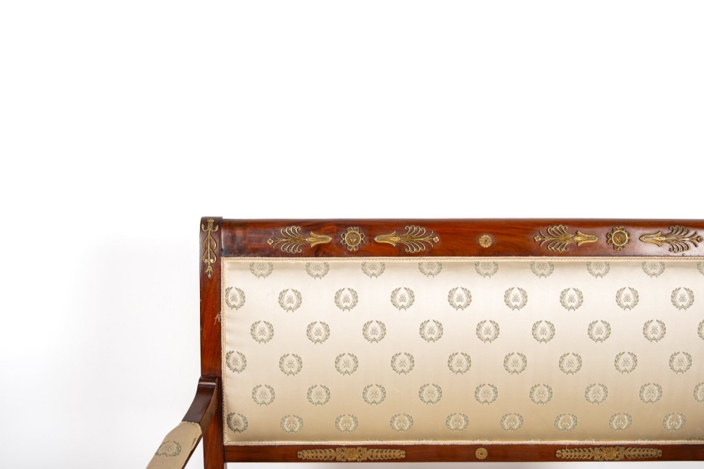 A three-piece antique French Empire Revival salon suite comprising a mahogany two-seater settee and two matching side chairs with gold silk laurel wreath upholstery and ormolu mounts. View V