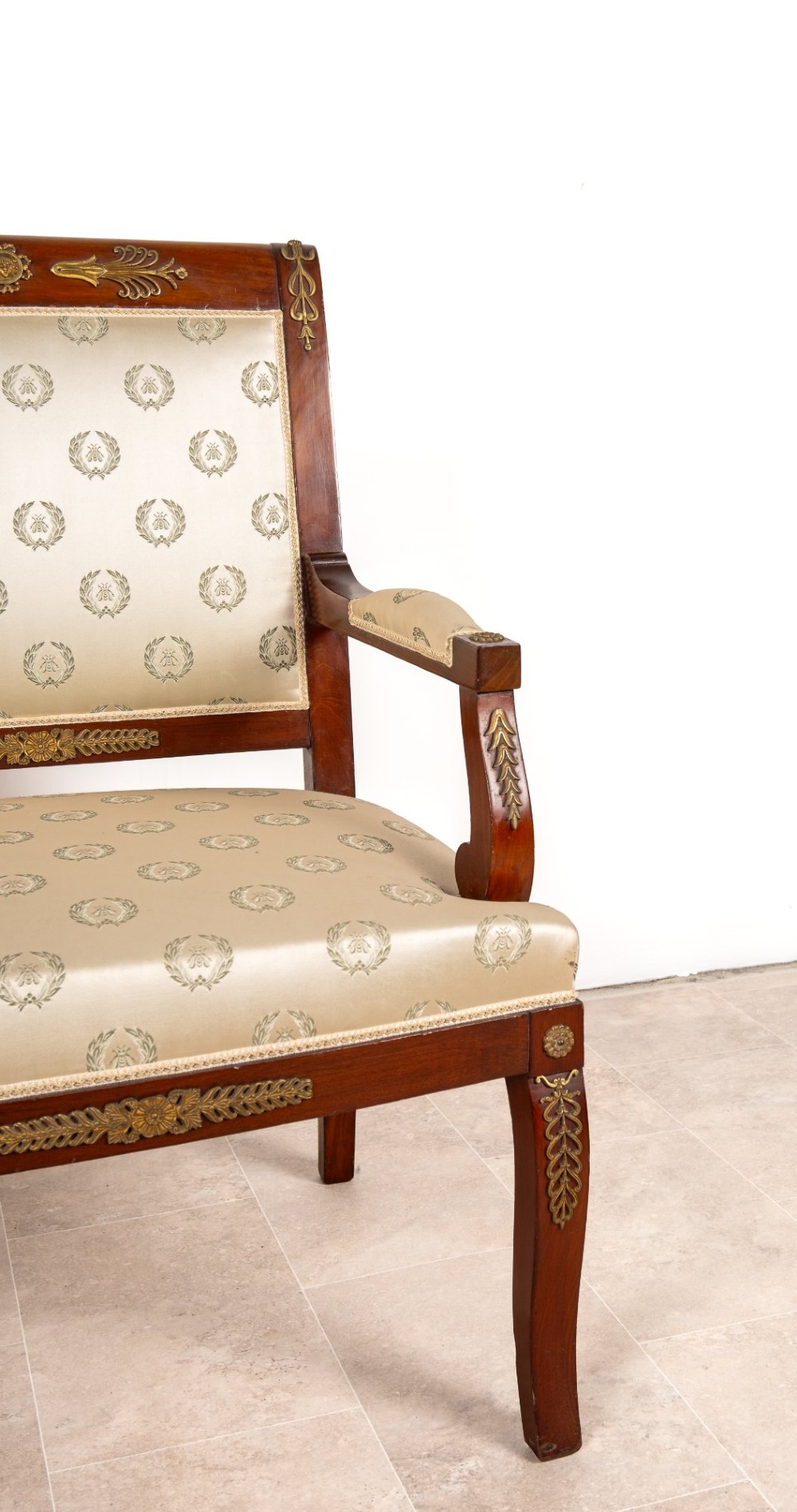 A three-piece antique French Empire Revival salon suite comprising a mahogany two-seater settee and two matching side chairs with gold silk laurel wreath upholstery and ormolu mounts. View VI