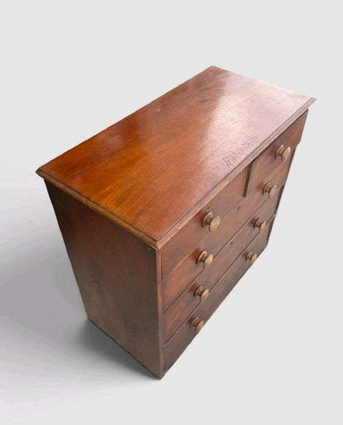 A Victorian pine chest of drawers featuring two short drawers over three long drawers with turned wooden knobs and keyholes. View VI