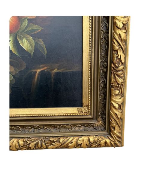 An antique oil painting depicting a detailed still life of grapes and peaches on a dark background, set within an ornate carved giltwood frame. View II