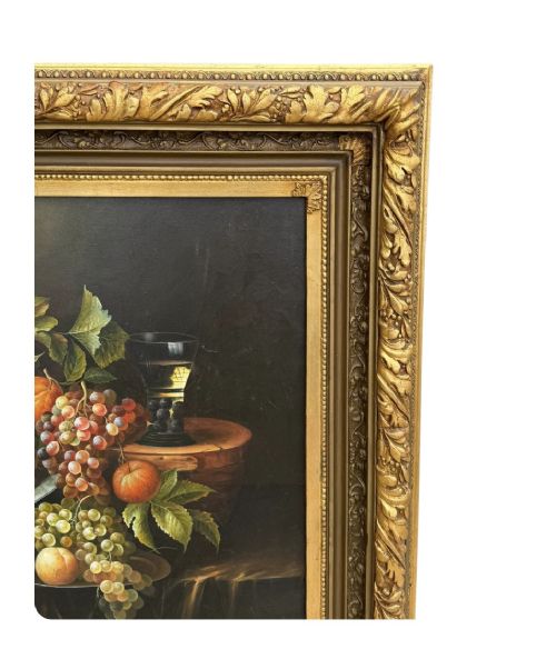 An antique oil painting depicting a detailed still life of grapes and peaches on a dark background, set within an ornate carved giltwood frame. View III