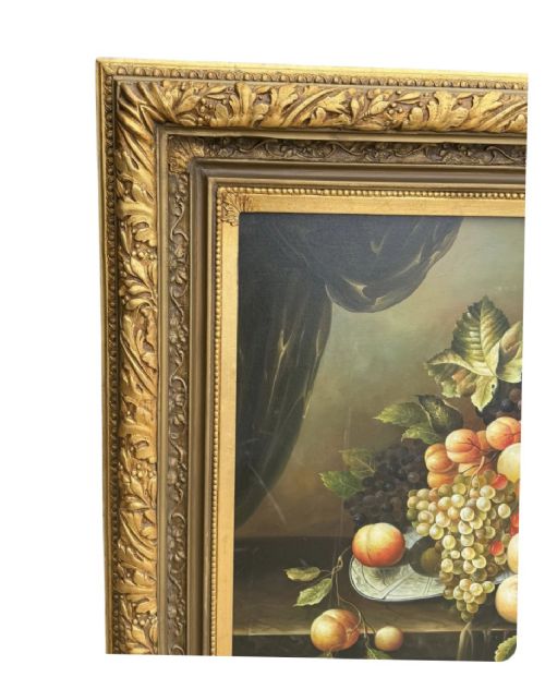 An antique oil painting depicting a detailed still life of grapes and peaches on a dark background, set within an ornate carved giltwood frame. View IV