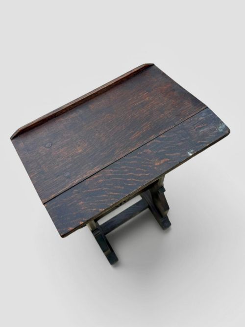 fig 1. A dark oak antique prayer desk featuring a slanted bookrest shelf, carved gothic side supports, and a built-in kneeling platform.