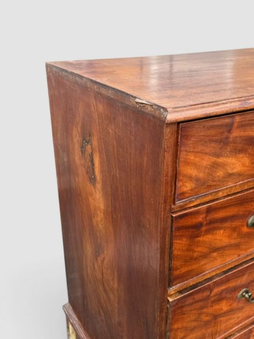 fig 3. A Georgian mahogany chest of drawers featuring a two-over-three drawer configuration with brass swan-neck handles and bracket feet.