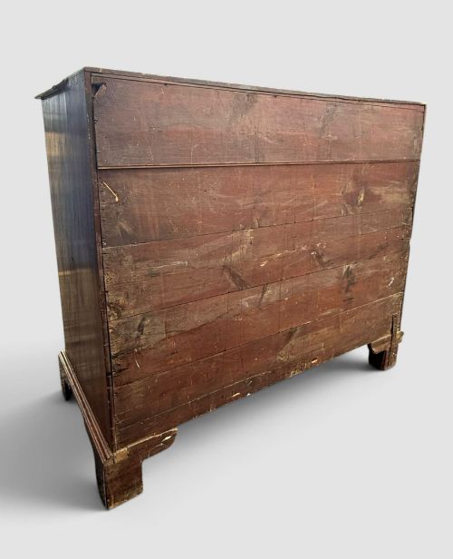 fig 4. A Georgian mahogany chest of drawers featuring a two-over-three drawer configuration with brass swan-neck handles and bracket feet.