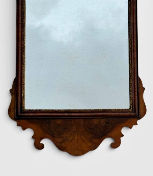 fig 1. An 18th-century Georgian wall mirror featuring a carved walnut fretwork frame with a central gilded plume motif at the top.