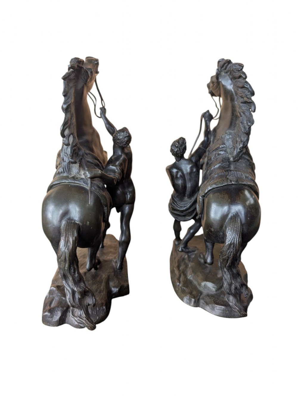 A pair of dark bronze sculptures depicting rearing horses restrained by standing grooms on naturalistic rock bases. View VIII