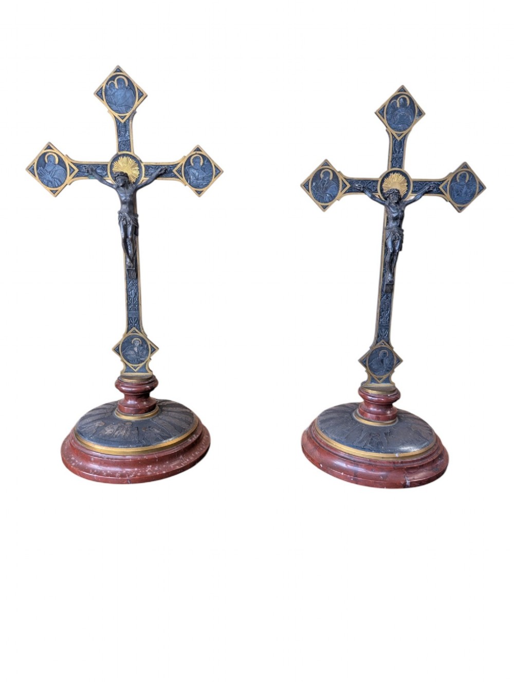 A pair of French Art Nouveau standing altar crucifixes in dark bronze and brass mounted on rounded red marble bases.