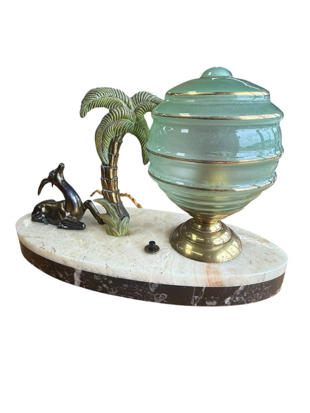 An Art Deco table lamp with a green stepped glass shade, metal palm tree, and reclining gazelle figure on an oval white marble base. View III