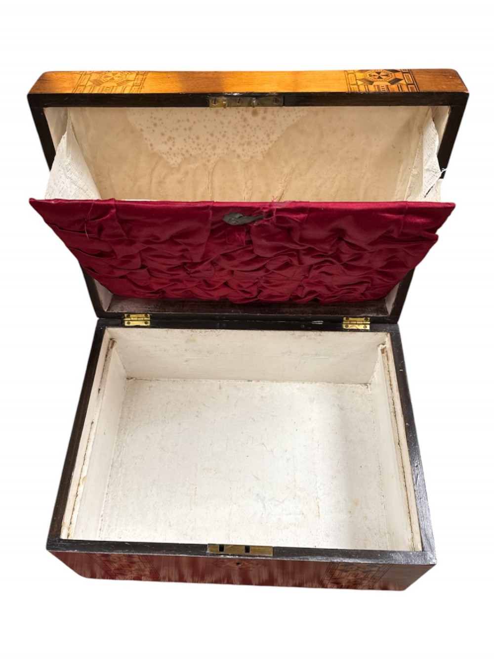 An open antique Victorian wooden sewing box featuring geometric Tunbridge ware mosaic inlay and a red ruched silk interior with removable tray compartments. View V