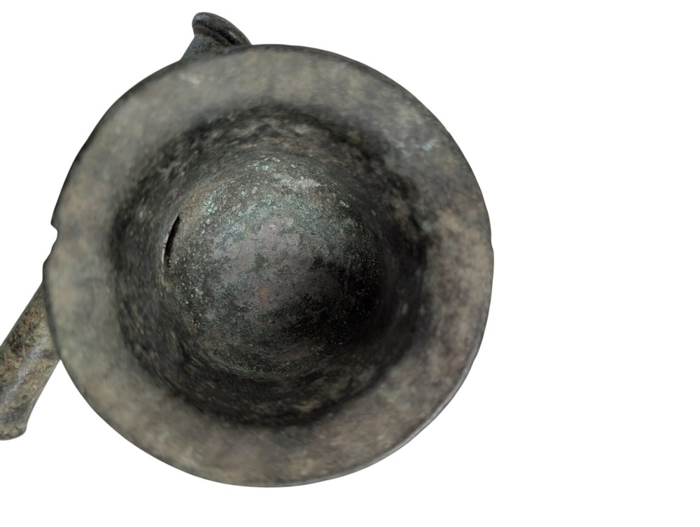 An antique cast bronze mortar and pestle displaying an aged surface patina with a flared rim and turned central ridge. View VII