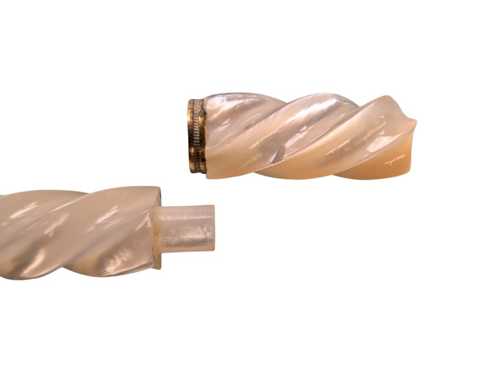 Two 19th-century mother-of-pearl needle cases, one featuring a carved spiral design and the other a smooth rectangular shape with rounded ends. View III