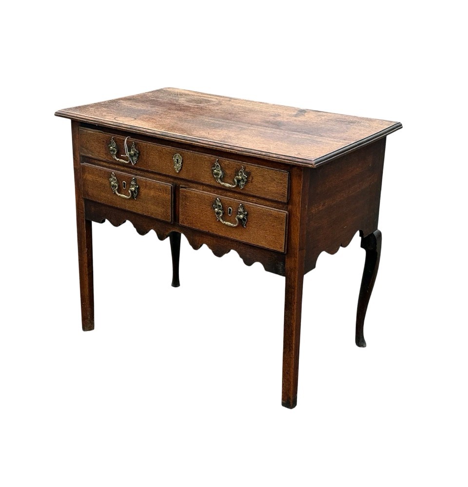 An 18th-century Georgian oak lowboy table featuring one wide upper drawer, two lower drawers, decorative brass handles, and a shaped apron. View III