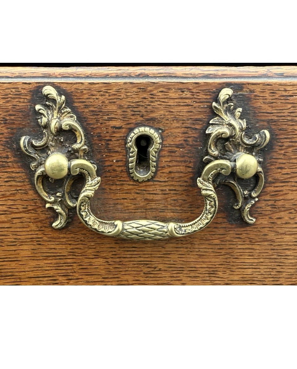 An 18th-century Georgian oak lowboy table featuring one wide upper drawer, two lower drawers, decorative brass handles, and a shaped apron. View V