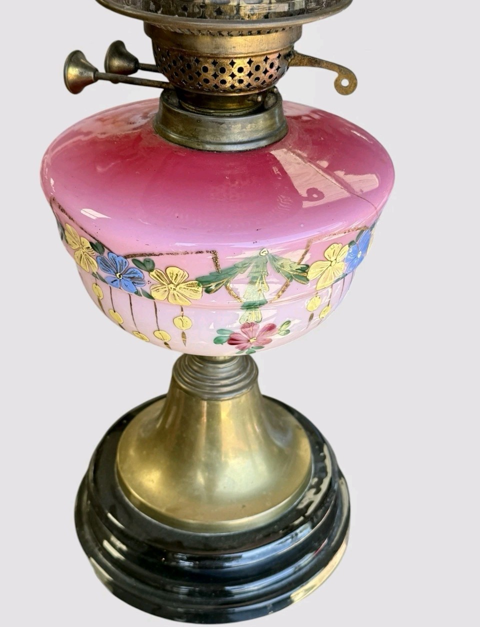 A Victorian cranberry glass oil lamp with a ruffled etched shade, hand-painted floral reservoir, brass burner, and stepped black base. View VIII