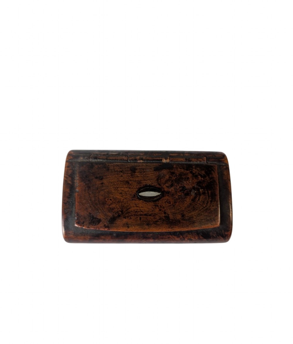 A 19th-century rectangular dark burr wood snuff box with an oval centre inlay and integrated wooden hinges.