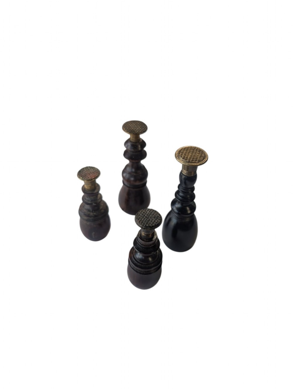 A set of four antique turned wooden wax seals featuring baluster handles and textured brass matrix heads.