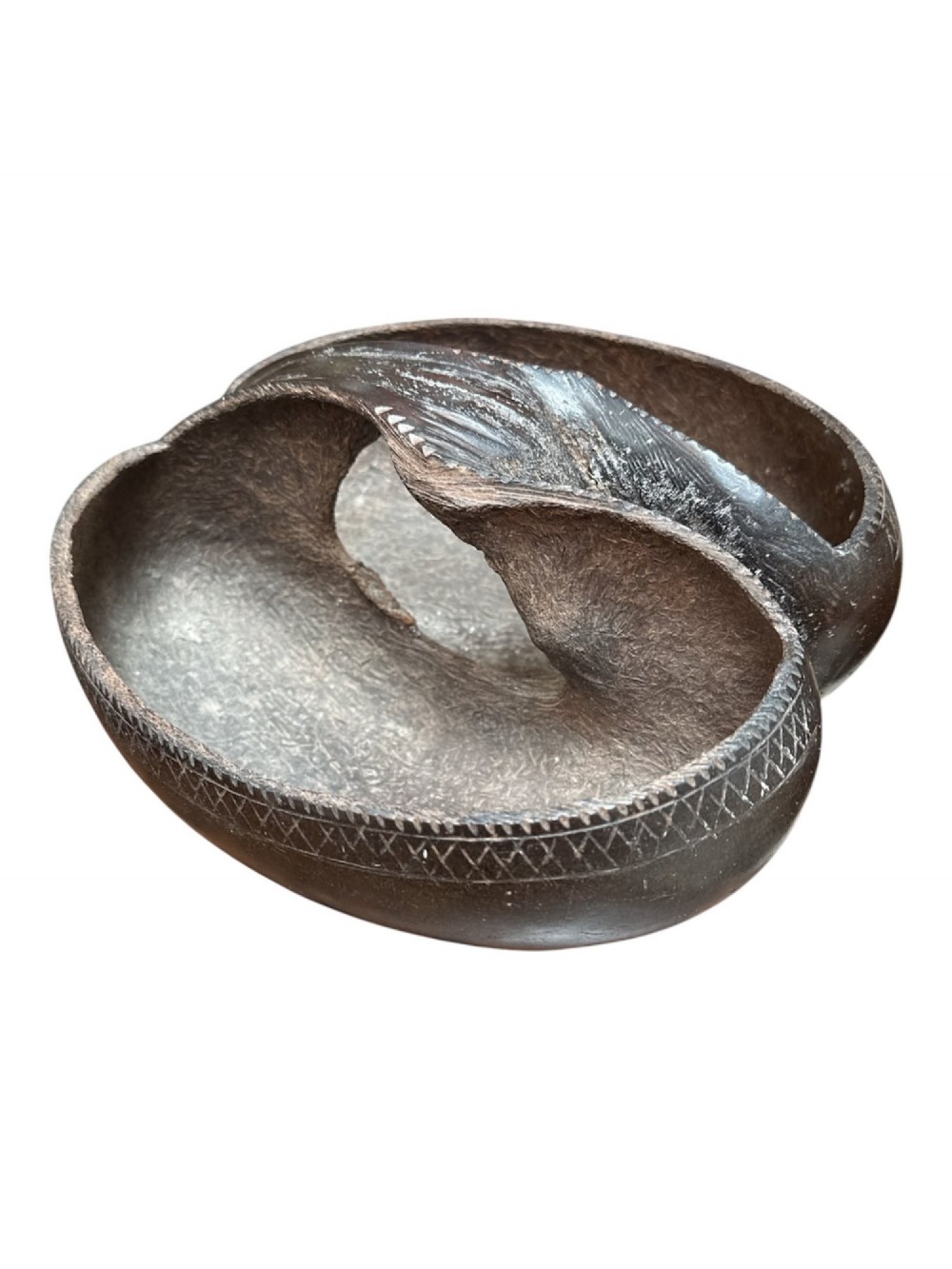 A dark brown carved Coco de Mer nut shell fashioned into a basket vessel with a central handle and incised geometric rim detailing. View IV