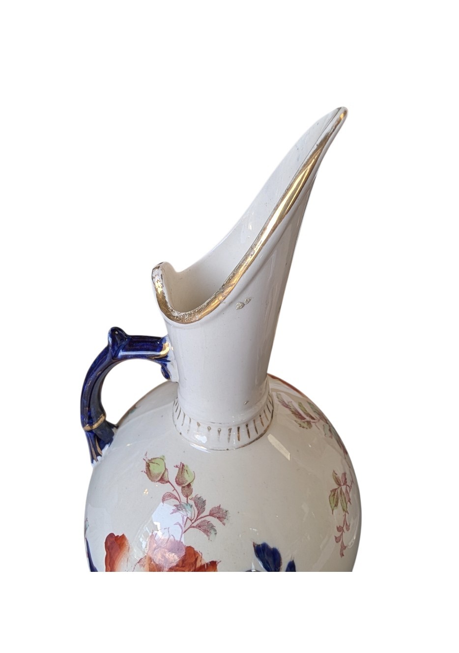 A pair of antique Japanese Imari porcelain pitchers featuring rounded bodies, tall swept spouts, dark blue handles, and hand-painted rust red flowers with gilded accents. View VI