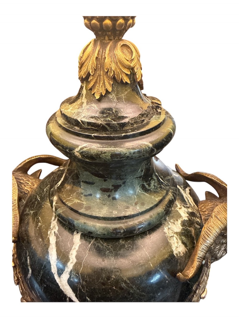 A pair of 19th-century French table lamps crafted from dark veined marble in urn shapes with gilt metal mounts and amber fabric shades featuring fringe trim. View V