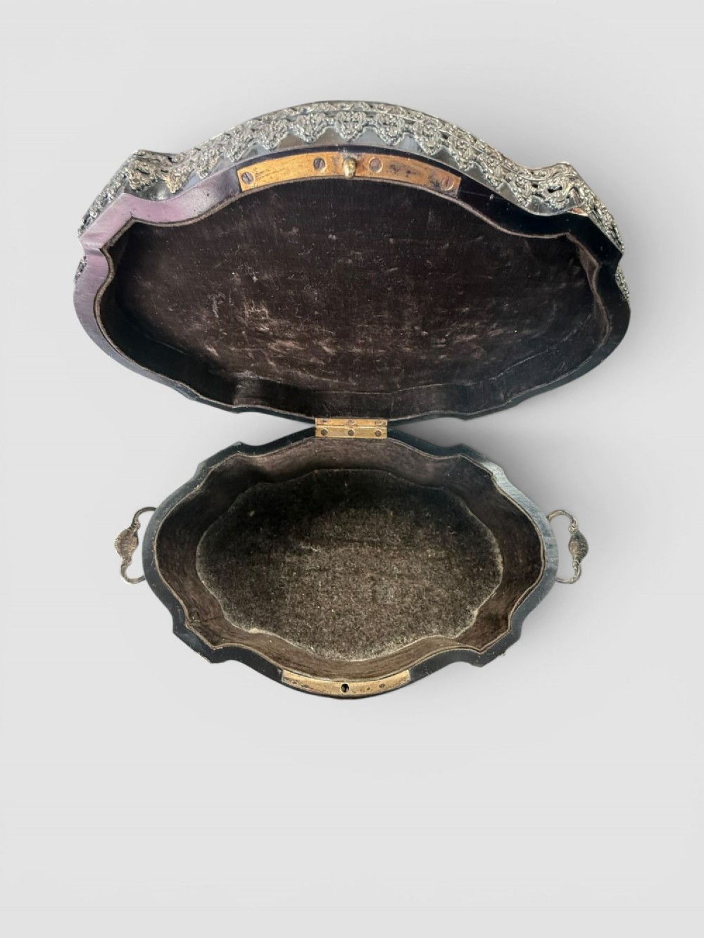 A 19th-century French ebonised serpentine table casket featuring elaborate silvered metal scrollwork mounts, raised feet, and a lid top decorated with a winged bird finial. View VI